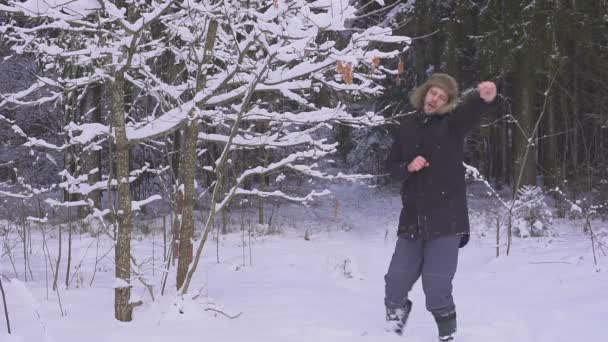 Logo feriados de Natal. homem feliz dançando na floresta de inverno e tremendo árvores — Vídeo de Stock