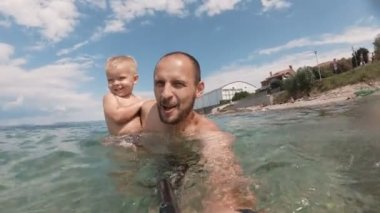 Mutlu baba ve oğlu bir selfie birlikte sahilde alarak