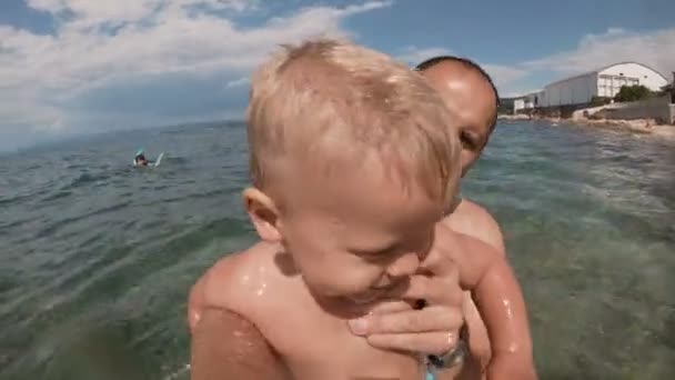 Szczęśliwy ojciec i jego syn biorąc selfie razem na plaży — Wideo stockowe