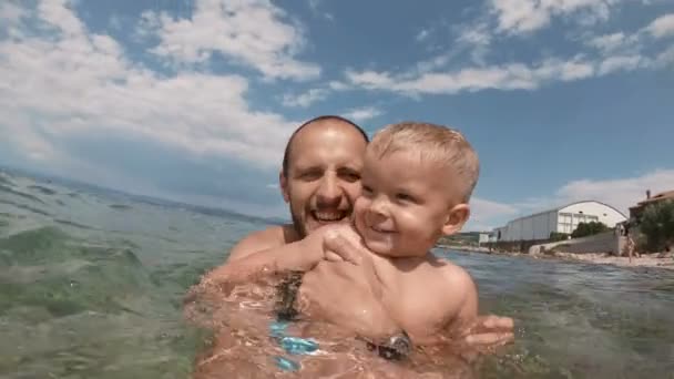 Szczęśliwy ojciec i jego syn biorąc selfie razem na plaży — Wideo stockowe