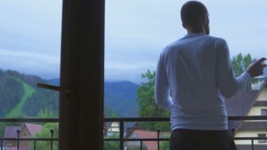 Genç adam onun odasından bir kadeh şarap, balkona bak dağlar gider.