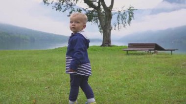 küçük çocuk dağ göl kenarında yürüyor. Çalışan ve doğada eğlenirken. Ağır çekim