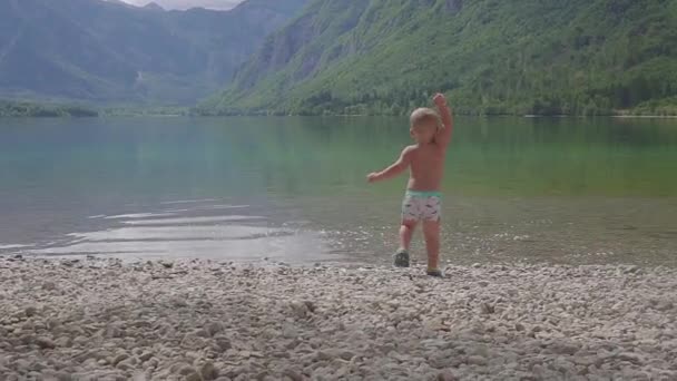 Menino 2 anos na água do lago da montanha da floresta. Vista de trás . — Vídeo de Stock