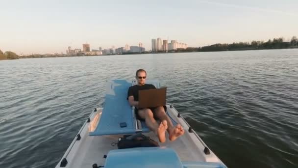 Νέος ελεύθερος επαγγελματίας εργάζεται στον υπολογιστή σε μια βάρκα. Απομακρυσμένης επιχείρησης. παθητική κέρδη — Αρχείο Βίντεο