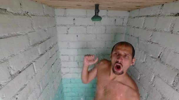 Giovane bell'uomo divertente si fa una doccia. balla sotto la doccia. rallentatore — Video Stock