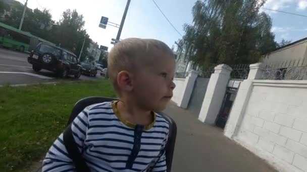 Chłopiec dziecko siedzi na krześle roweru podczas jazdy i rozglądając się — Wideo stockowe