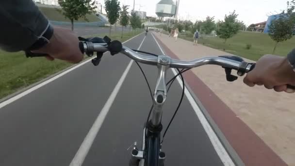 路上市で s で自転車に乗る男。実権を握って両手で表示します。 — ストック動画