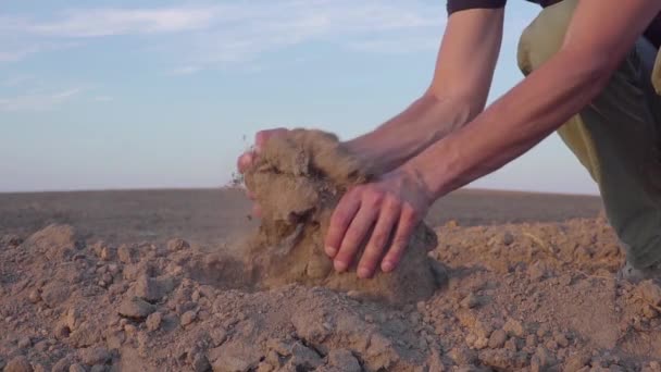 Замедленное видео, где человеческие руки держат земную пыль. Засуха, земля без дождя — стоковое видео