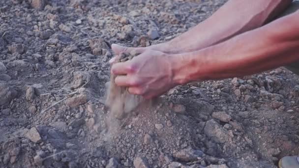 Повільний відеоролик рук людей містить пил із землі. Посуха, земля без дощу. — стокове відео