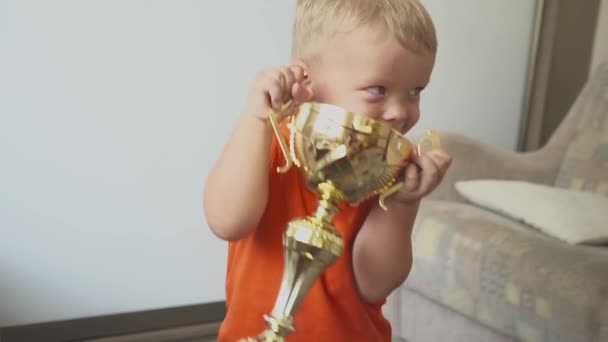 Baby boy vicces sportember. gyermek a díjat. A nagy csésze. Siker és a győztes koncepció — Stock videók