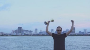 Şehir akşam ellerine bir kaba olan genç bir adam. Kavram olarak zafer, başarı ve şampiyonu.