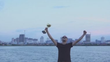 Şehir akşam ellerine bir kaba olan genç bir adam. Kavram olarak zafer, başarı ve şampiyonu.