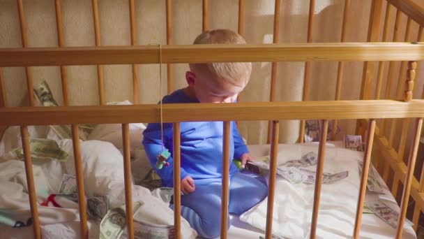 Schattige kleine babyjongen onder een dollar regen in bed. Concept van erfgoed. — Stockvideo