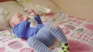 sevimli küçük oğlu yatakta bir doları yağmur altında. Miras kavramı.