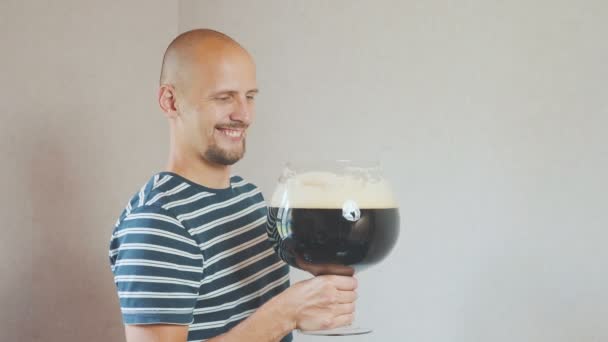 Heureux, jeune homme avec une très grande tasse de bière. Il rit et se réjouit, puis boit. — Video