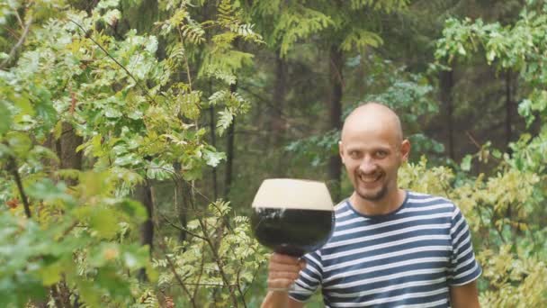 Çok büyük bir kupa bira ile mutlu, Genç adam. O gülüyor ve sevinir ve bira bahçesinde içme — Stok video