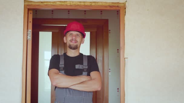 Portrait de joyeux barbu beau jeune constructeur adulte sur fond d'un appartement rénové — Video