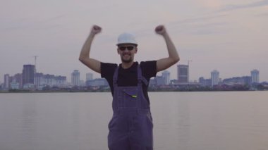 İnşaat işçisi sevinir ile atlama ve mutlu akşam şehrin.