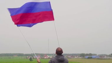 Video. adam Avrupa Birliği ve Rusya bayrakları ülke peyzaj sallıyor. Dostluk ve barış kavramı.