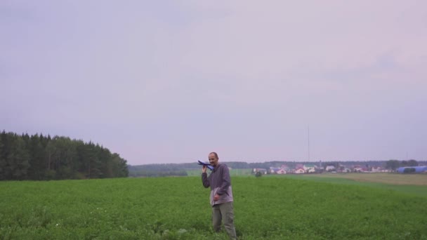 A happy family. The boy on his father playing with an airplane toy in field — Stock Video