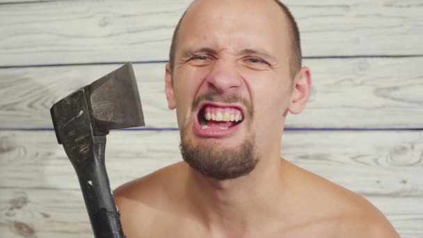 Agressief maar grappige maniac moordenaar met een bijl binnenshuis — Stockvideo