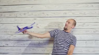 30-s adam oyuncak uçak ile oynuyor. Komik sahne.