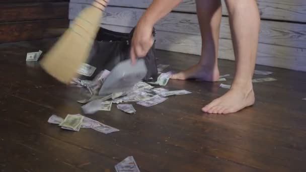 Мітла забирає долари в сміттєзвалище на підлозі. Поняття несподіваного багатства — стокове відео
