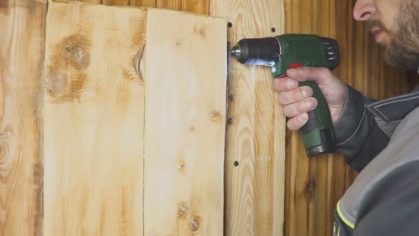 Pracownik konfiguruje self-made drzwi w wykończonym w drewnie — Wideo stockowe