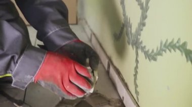 Çalışan küçük fayans mutfak duvar ayarlar. Elleri döşeme üzerinde yapışkan yerleştirir. çekim stedikam