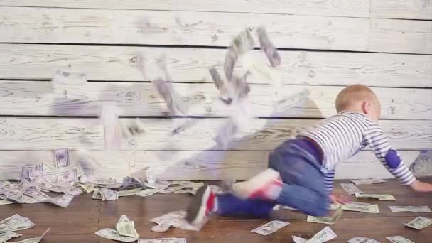 Niño de dos años y dinero caído. concepto de riqueza . — Vídeo de stock