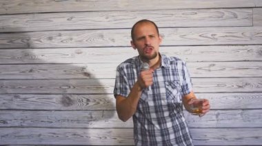 Bir bardak alkol tutarak ve parti üzerinde bir mikrofon şarkı sarhoş adam