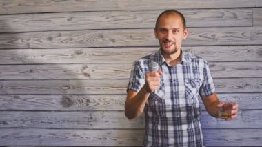 Bir bardak alkol tutarak ve parti üzerinde bir mikrofon şarkı sarhoş adam