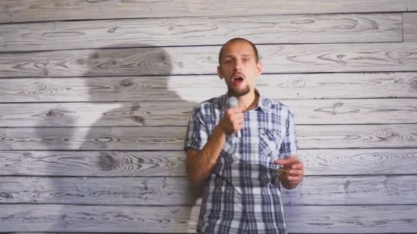 Een jonge man met een baard zingt een lied in karaoke. — Stockvideo