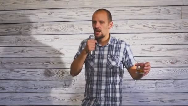 En ung man med ett skägg sjunger en låt i karaoke. — Stockvideo