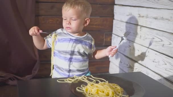 Twee oren oude Baby kind eten spaghetti thuis of childrens restaurant — Stockvideo