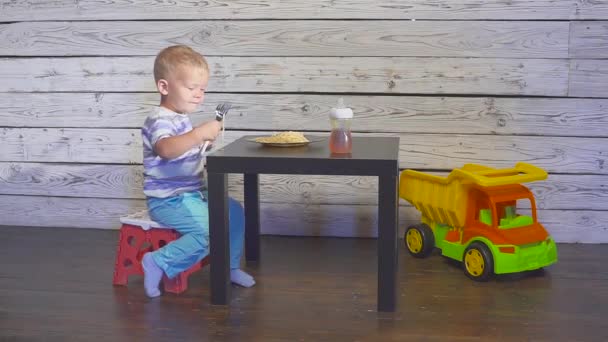Двома вухами стара дитина їсть спагеті вдома або дитячому ресторані — стокове відео