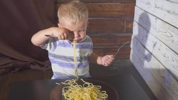 Dos orejas de edad Bebé niño comiendo espaguetis en casa o los niños restaurante — Vídeos de Stock