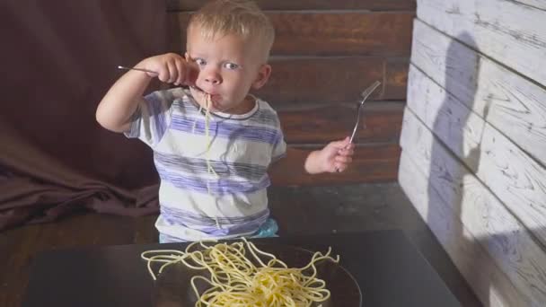Twee oren oude Baby kind eten spaghetti thuis of childrens restaurant — Stockvideo