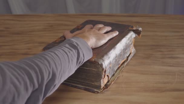 Чоловіча долоня на старій книзі, клятва на Біблії. Вид зверху — стокове відео