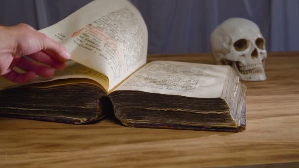 Magiczny obrzęd. Starożytna Księga i ludzką czaszkę. Koncepcja na Halloween — Wideo stockowe