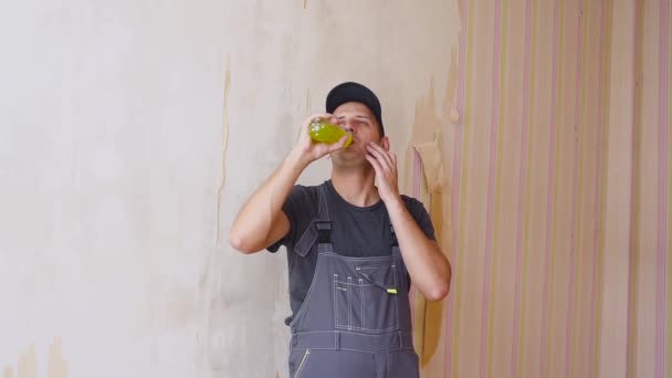 Bauarbeiter oder Bauarbeiter mit Genussgetränken aus einer Flasche im Inneren des im Bau befindlichen Gebäudes — Stockvideo