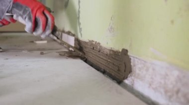Çalışan küçük fayans mutfak duvar ayarlar. Elleri döşeme üzerinde yapışkan yerleştirir. çekim stedikam. portre