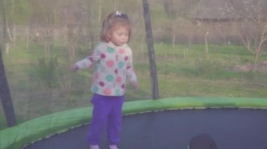 mutlu üç yaşındaki kız bir trambolin üzerinde atlama. Duygusal neşeli portre. Ağır çekim