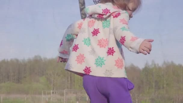 Šťastné tři roků stará dívka skákání na trampolíně. Emocionální radostné portrét. Zpomalený pohyb — Stock video