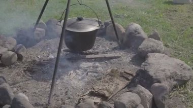 Söz konusu ormanda hazırlamak için sıcak taze yiyecek. Bir kazan ile sıcak taze çorba ya da güveç ya da yulaf lapası tehlikede. Bir ülke evin avlusuna gelsinler. Yakın çekim.