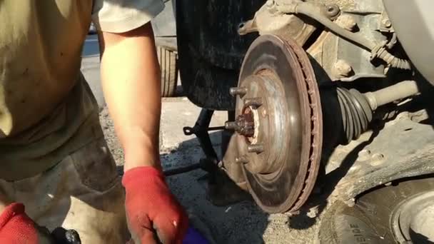 Auto makinist araba tamircisi frenler üzerinde çalışıyor. — Stok video