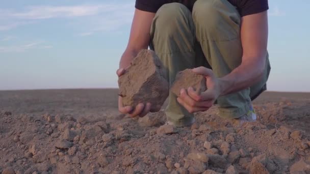 Замедленное видео, где человеческие руки держат земную пыль. Засуха, земля без дождя — стоковое видео