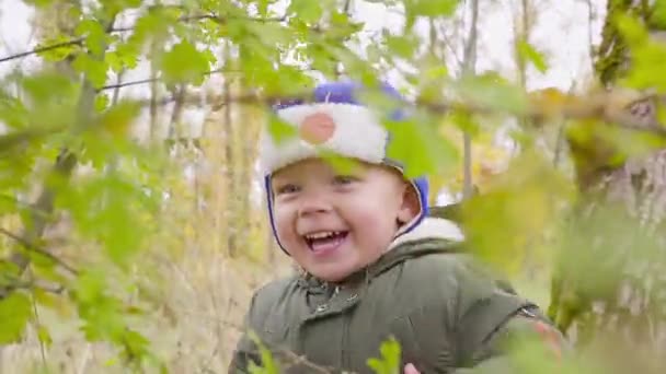 Portrait d'un garçon qui joue dans le parc d'automne et sourit — Video