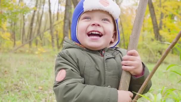 portrait d'un garçon qui joue dans le parc d'automne et sourit 