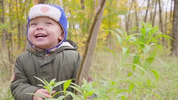 portrait d'un garçon qui joue dans le parc d'automne et sourit 